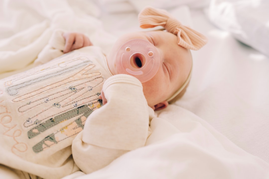 Newborn baby with pacifier and bow