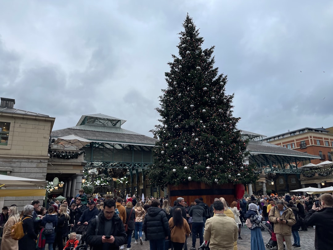 a group of people standing around a christmas tree
